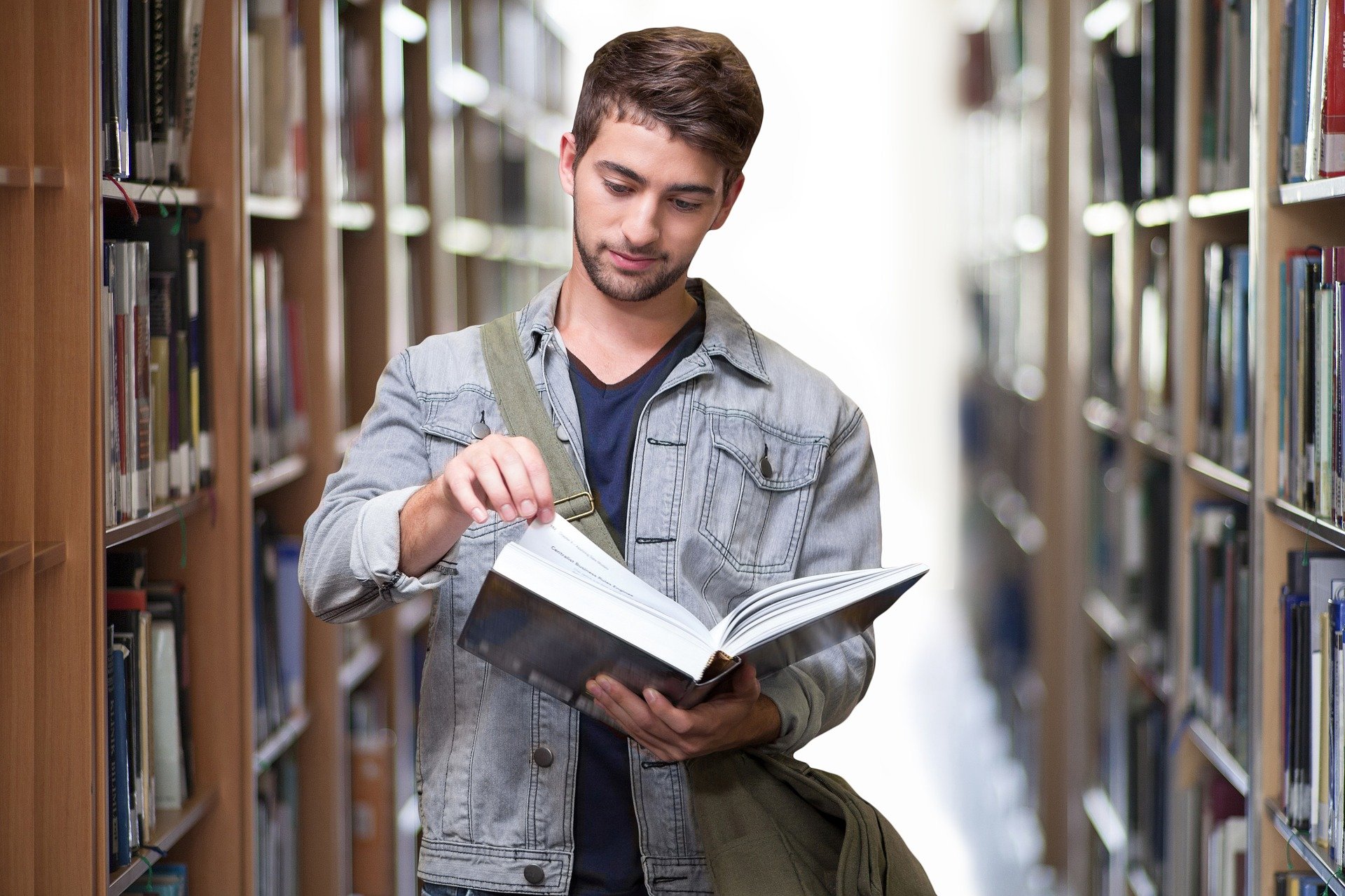 Student liest in einem Buch in der Bibliothek