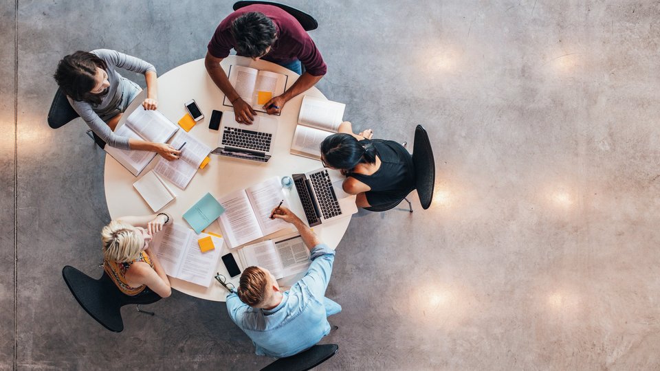 Studenten von oben an einem runden Tisch